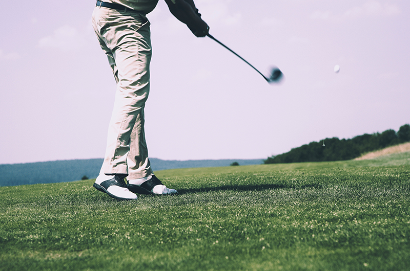 golfer taking swing on green